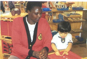 Christine Olanya works with a child at Riverwoods Montessori School